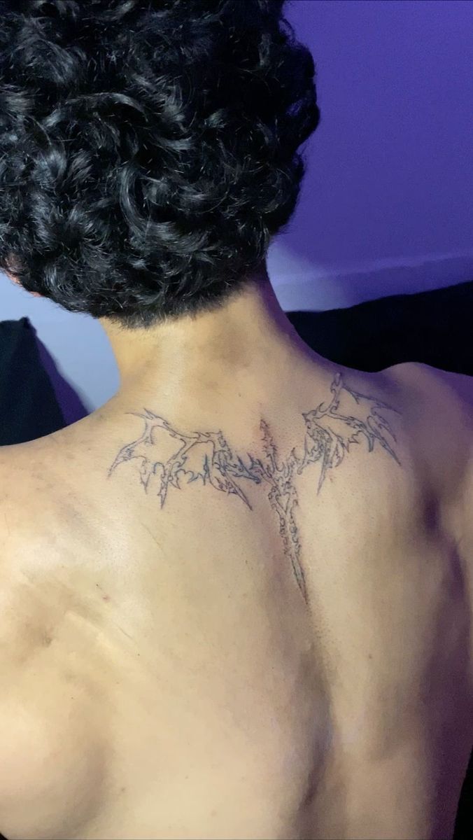 the back of a man's neck with tattoos on it