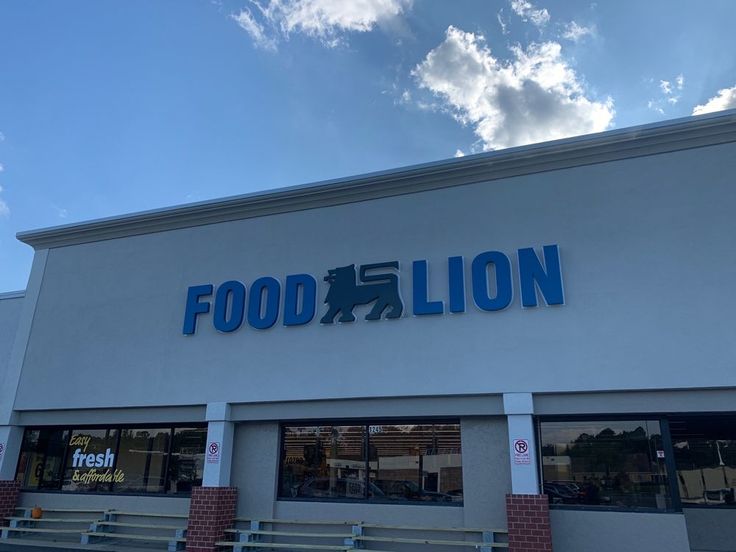 the front of a food lion store on a sunny day with clouds in the sky