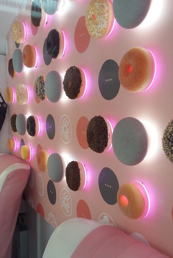 there are donuts on the wall with lights above them and behind it is a bed