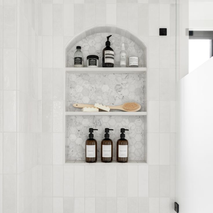 the shelves in the bathroom are filled with soaps and lotion bottles next to each other