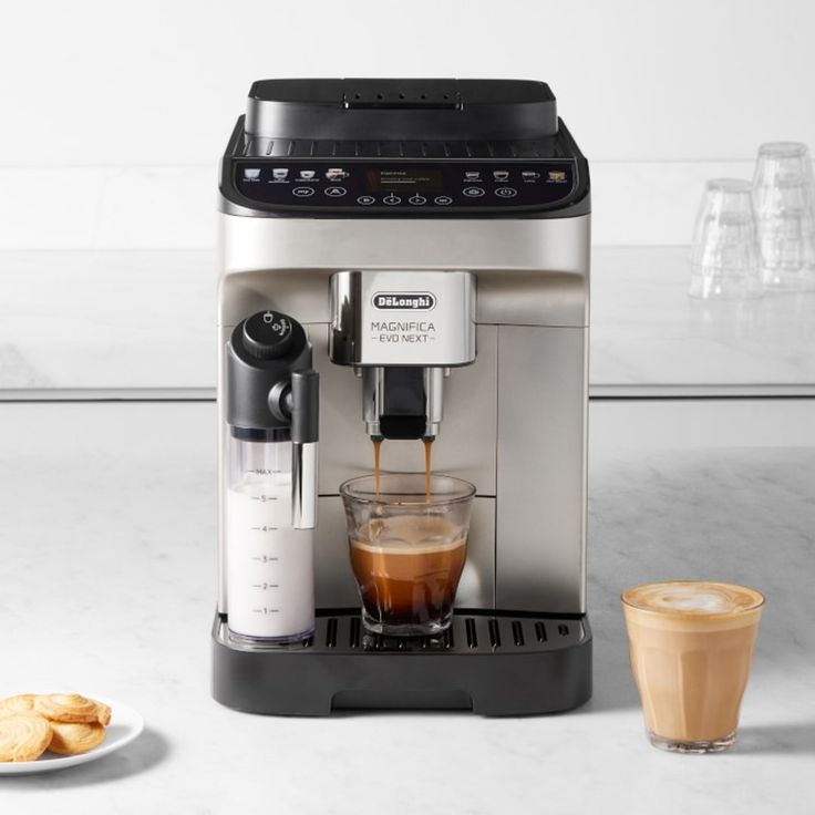 an espresso machine with two cups of coffee next to it