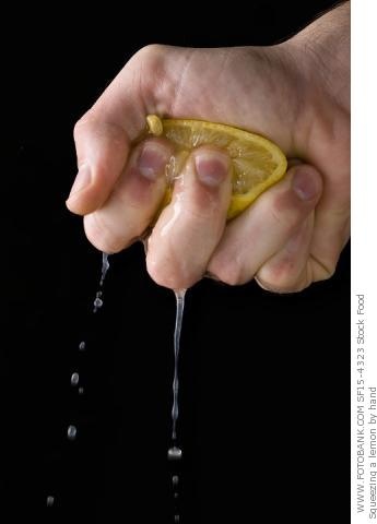 a person holding a lemon in their hand with water coming out of it and dripping from the top