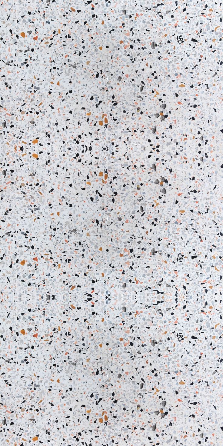 a white surface with black, orange and grey speckles on it's edges