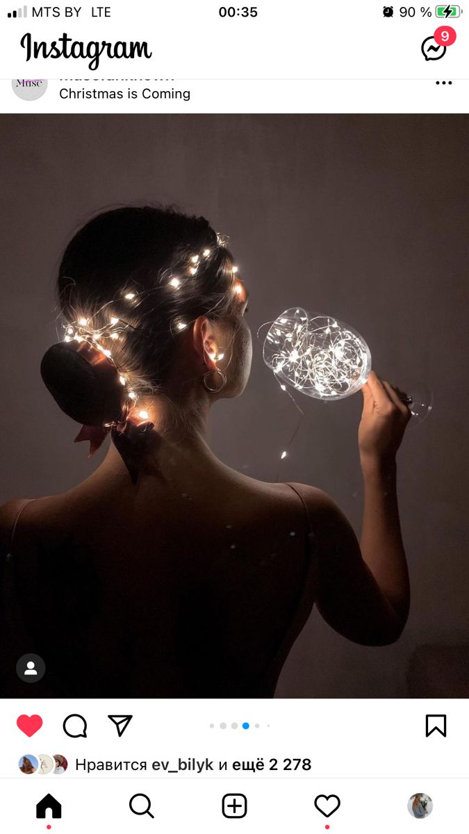 a woman with lights on her head holding a glass ball in front of her face