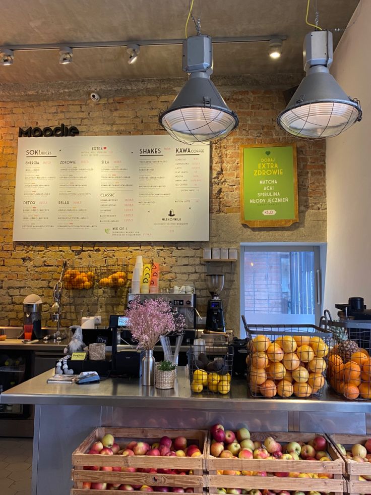 a counter with lots of fruits and vegetables on it in front of a brick wall