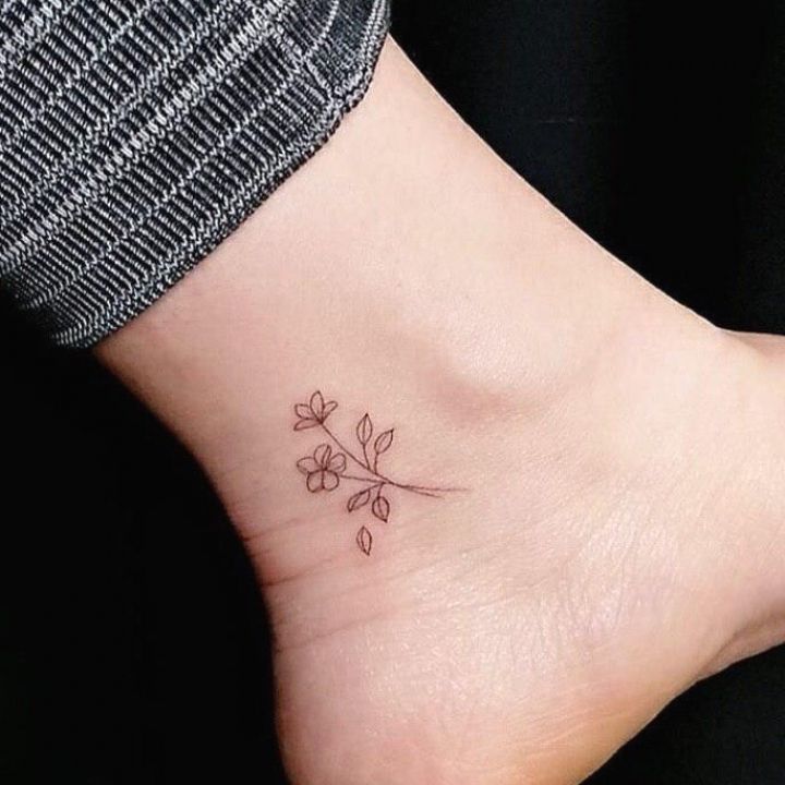 a small flower tattoo on the ankle