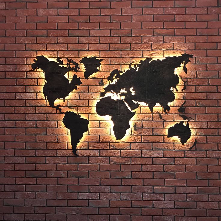 a brick wall with a world map cut into it's side and light shining through the middle