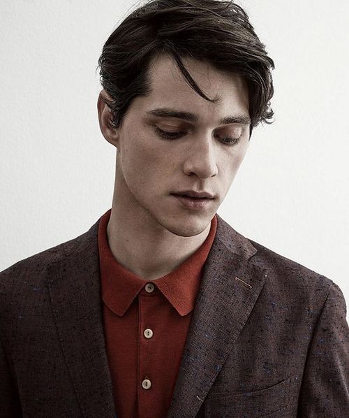 a young man wearing a suit and red shirt