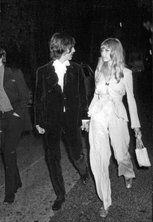 black and white photograph of two people walking down the street at night with one person wearing a tuxedo