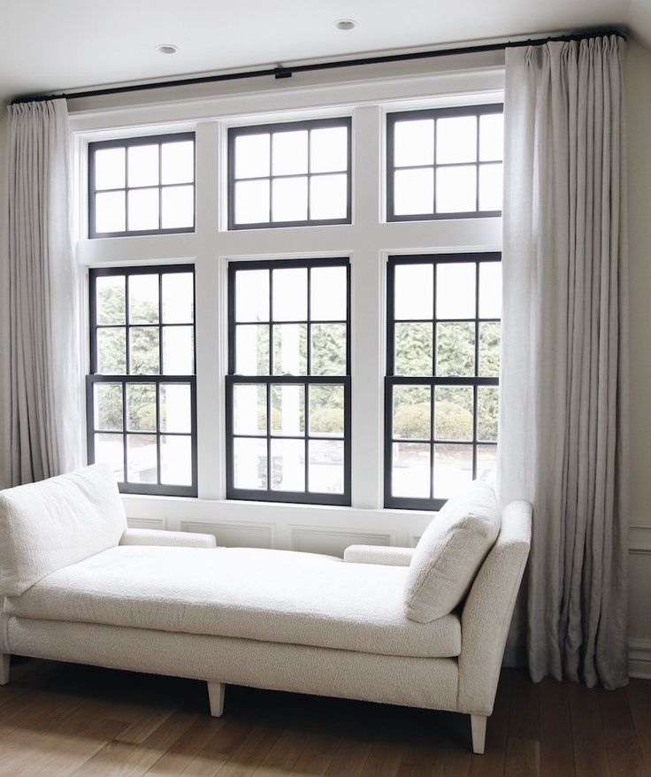 a white couch sitting in front of a window