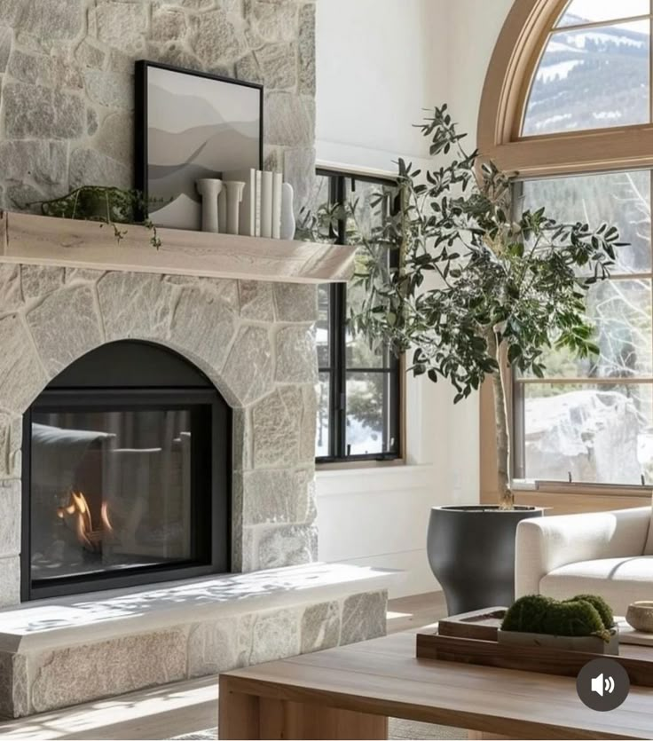 a living room filled with furniture and a fire place in front of a stone fireplace