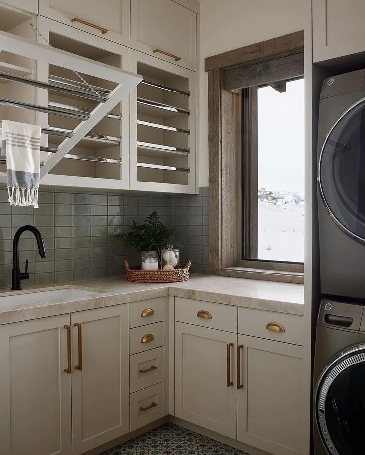 a washer and dryer in a kitchen next to a window with shutters