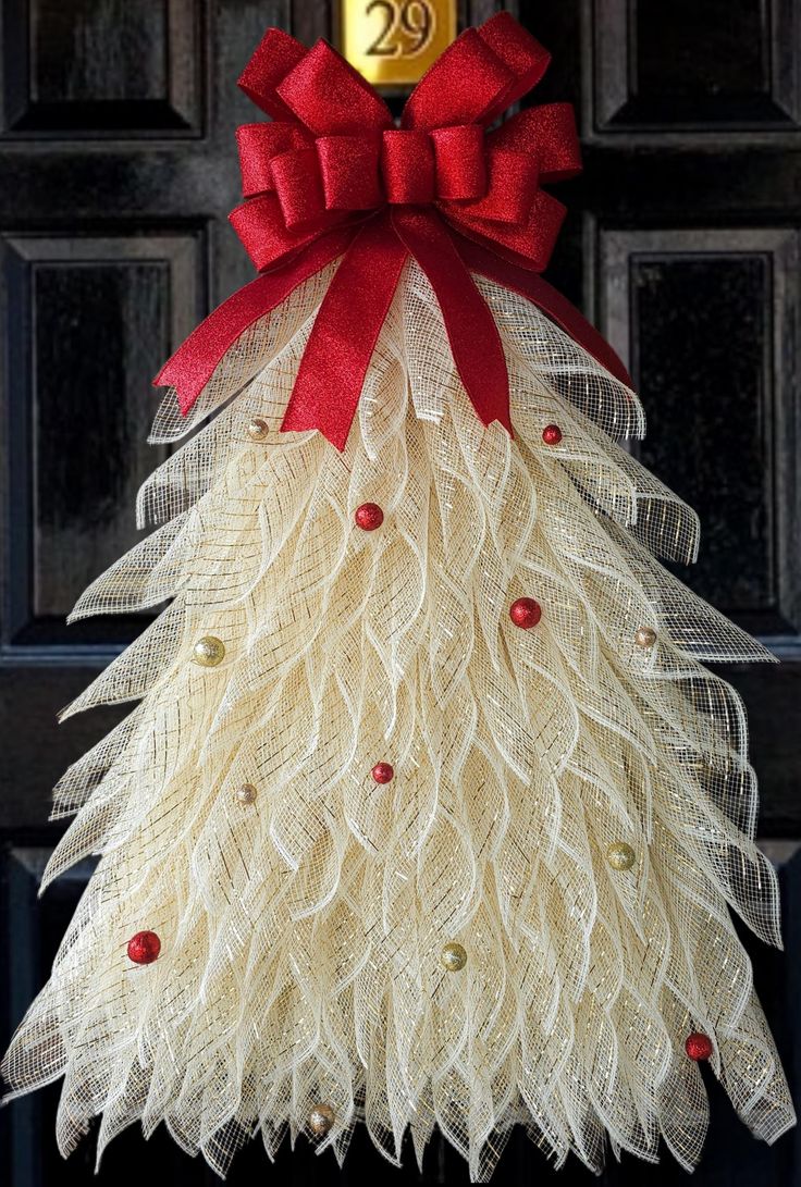 a christmas tree made out of burlocks and red bows on the front door