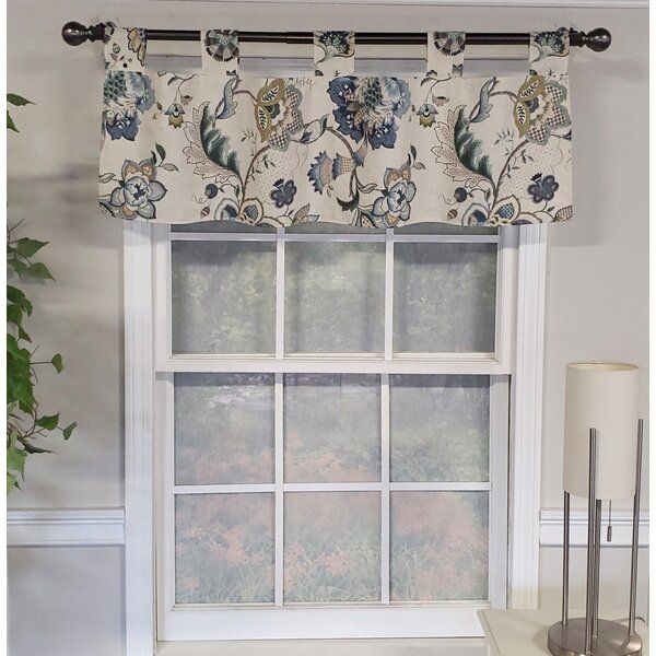 a window with a flowered valance hanging from it's side, next to a lamp