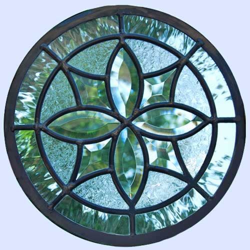 a circular stained glass window with leaves on it