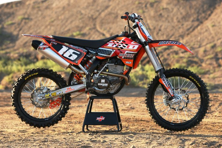 a dirt bike parked on top of a metal stand in the middle of a field