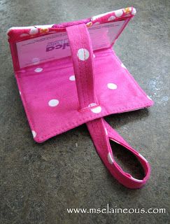 a pink wallet with white polka dots on it sitting on top of a cement floor