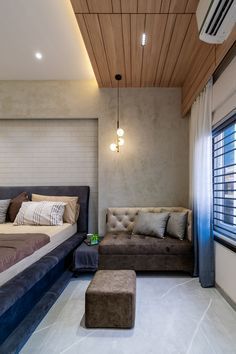 a bed sitting next to a couch in a bedroom on top of a hard wood floor