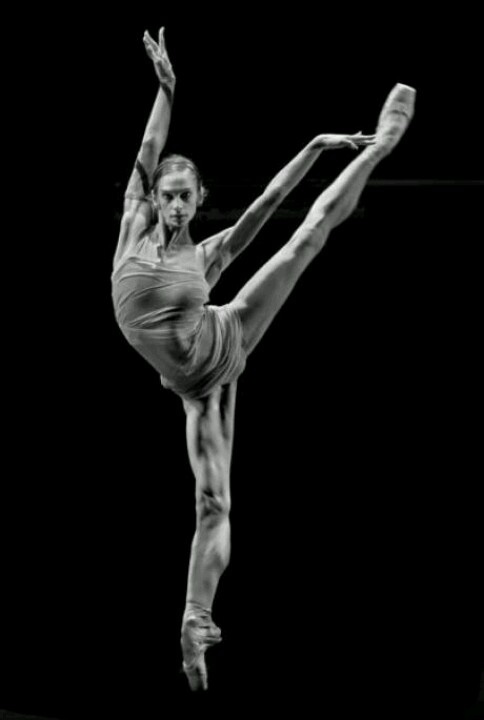 a woman doing a handstand in the air with her legs spread out and one leg bent