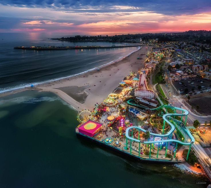 an aerial view of the beach and amusement park at sunset or sunrise, from above