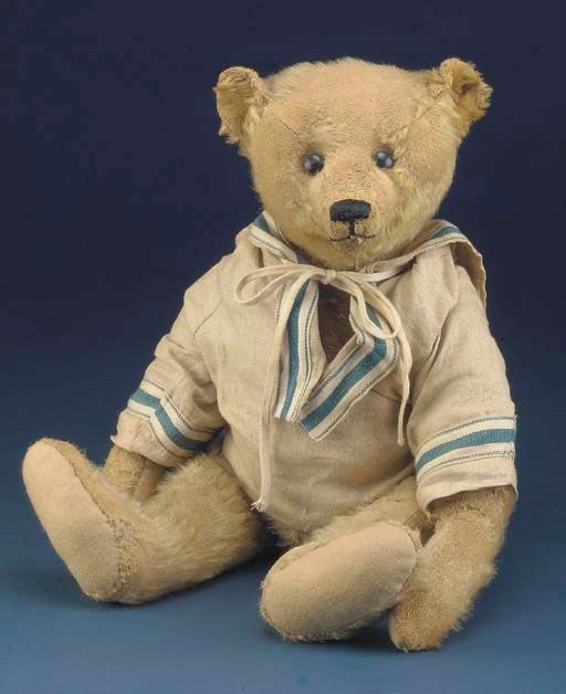 a teddy bear wearing a shirt and tie sitting in front of a blue background,