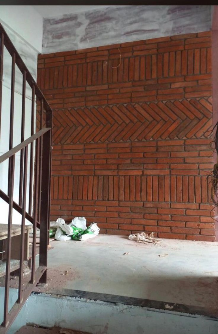 a brick wall in the corner of a room with a window and bars on it