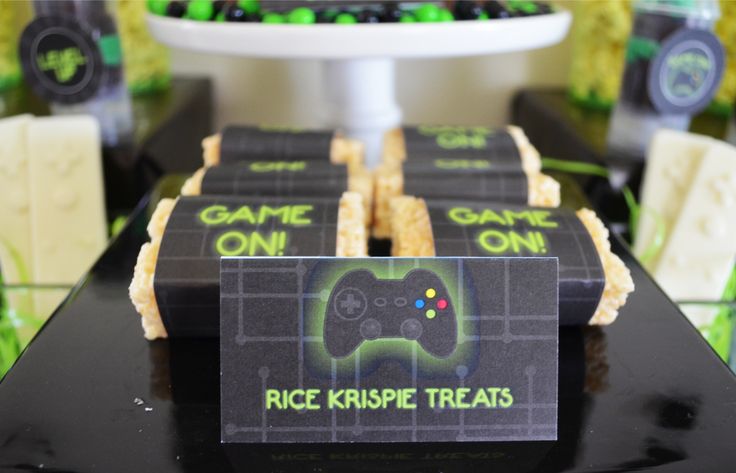 some cookies are sitting on a table with video game treats in front of them that say rice krispies treats