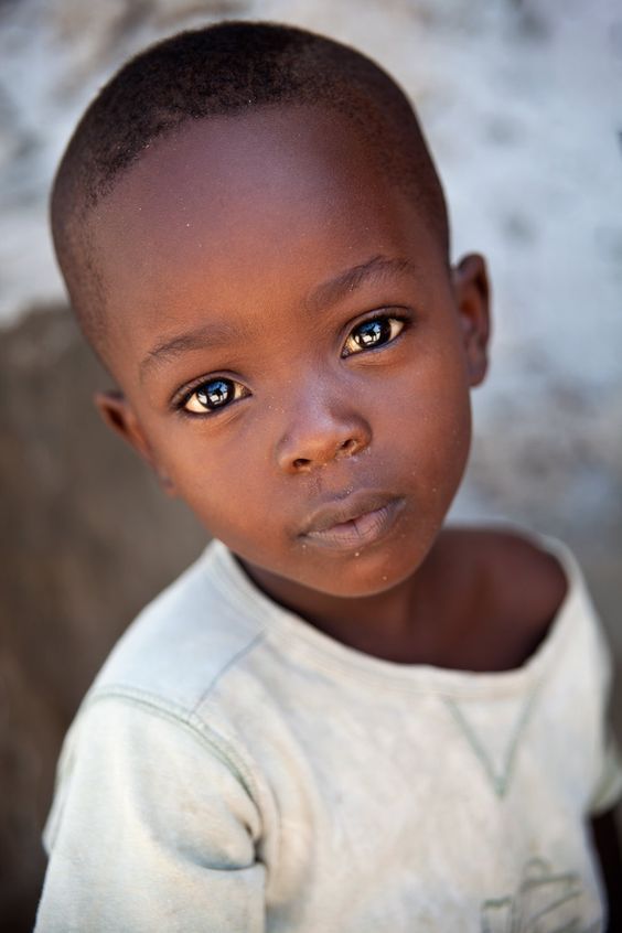 a young boy with blue eyes looking at the camera