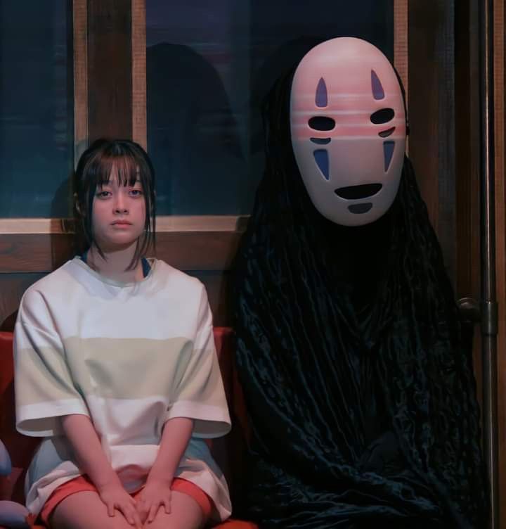 a woman sitting next to a man wearing a mask