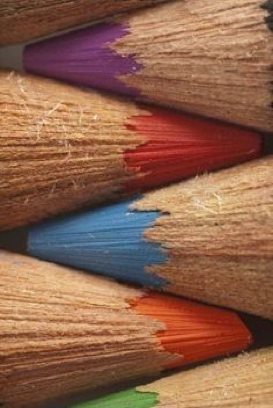 several colored pencils are lined up in a close up view, with the top one showing