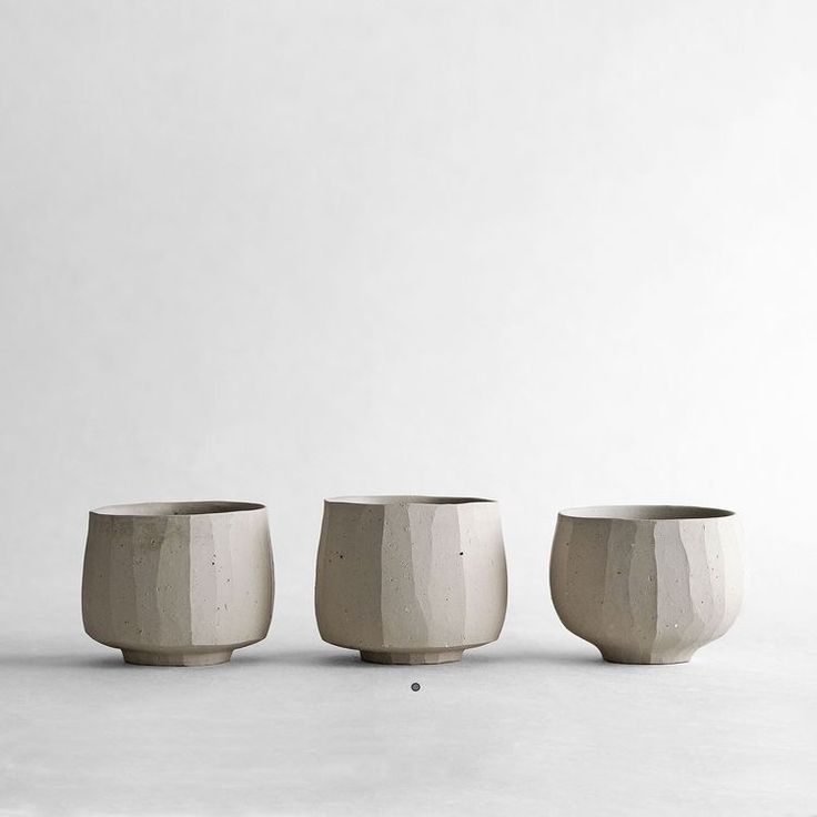 three white vases sitting next to each other