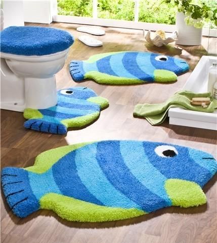 two blue and green fish rugs sitting on top of a wooden floor next to a toilet