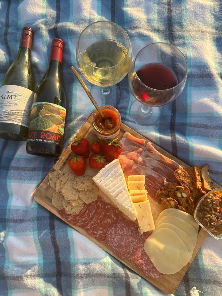 wine, cheese and meat on a picnic blanket