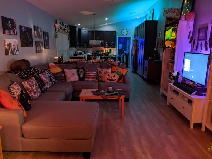 a living room filled with furniture and a flat screen tv sitting on top of a wooden floor