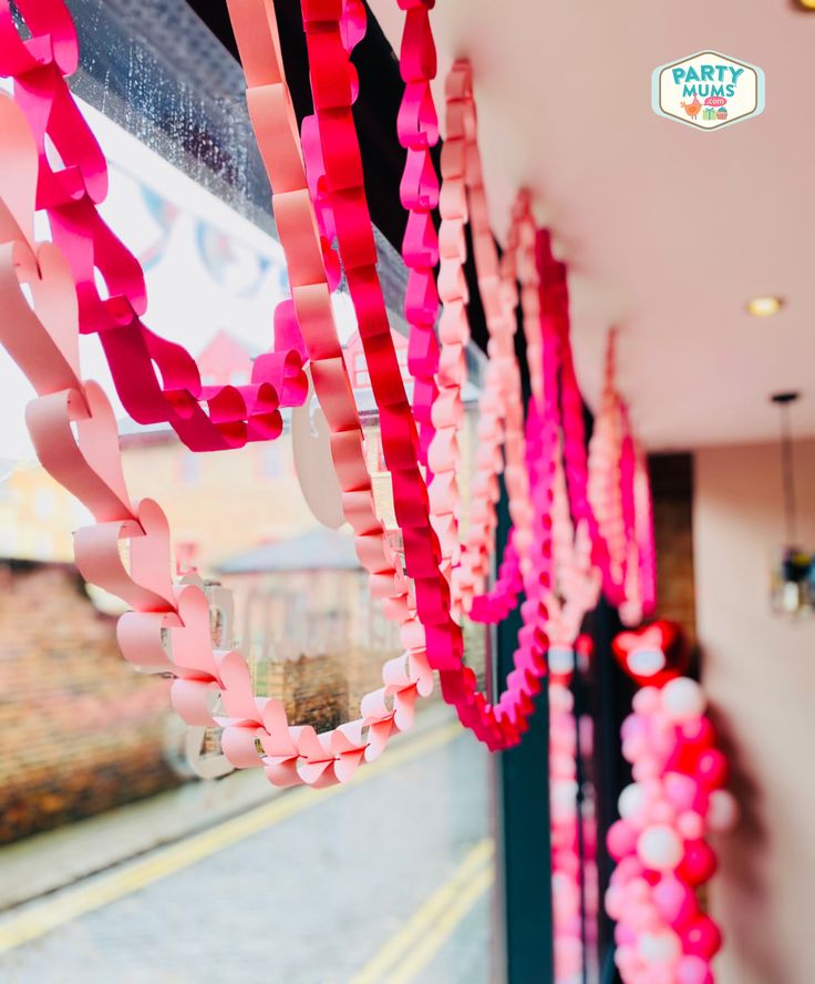 pink and red streamers hanging from the side of a building