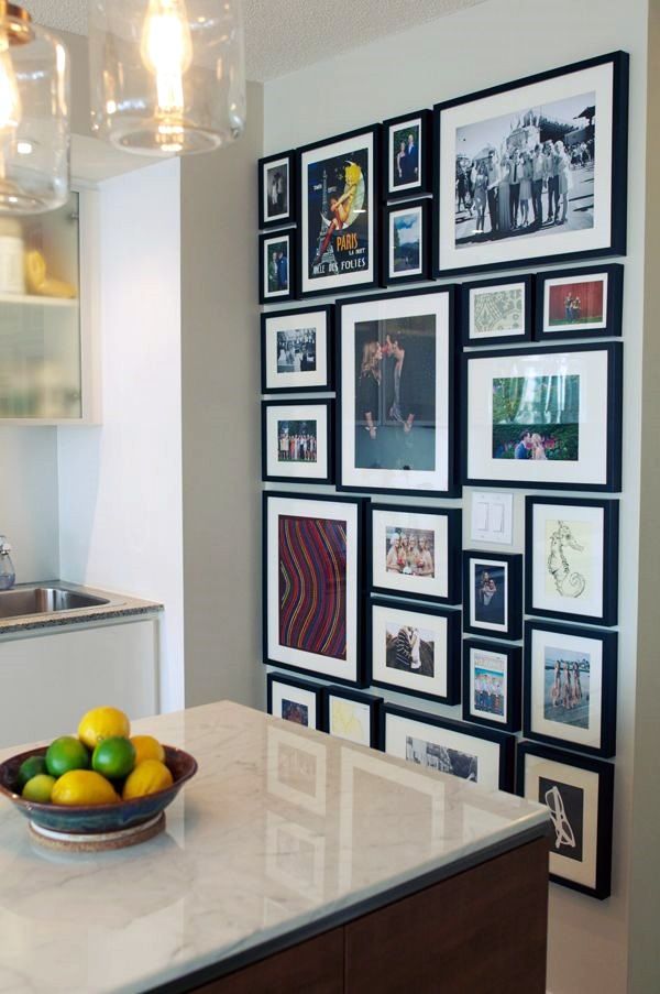 a bowl of fruit sitting on top of a counter next to a wall covered in pictures