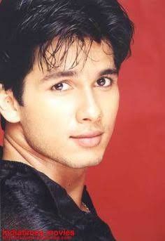 a close up of a person wearing a black shirt and posing for a photo with a red background