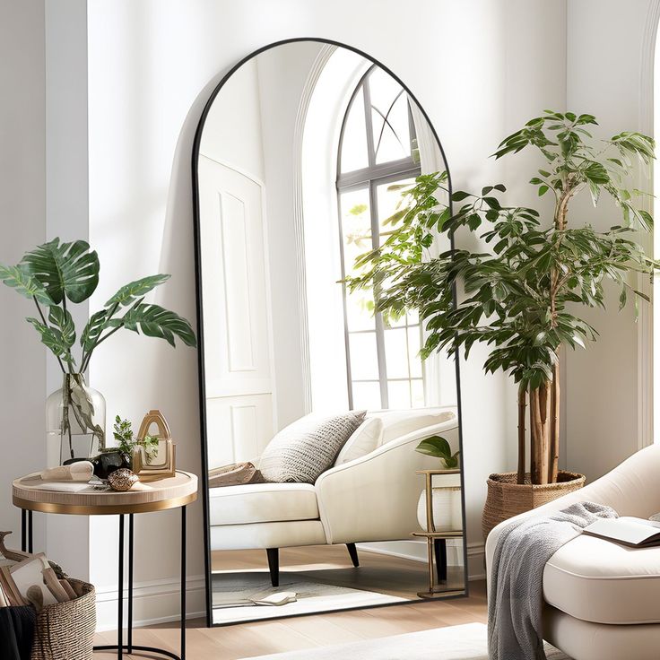 a living room filled with furniture and a large mirror on the wall next to a couch