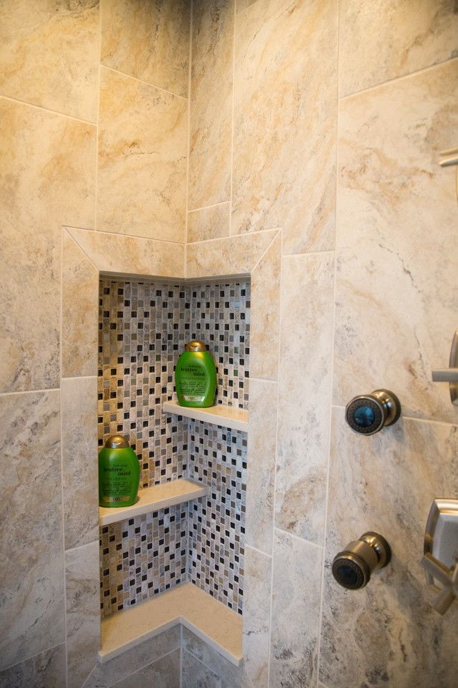 there is a shower with some shelves in the corner and soap dispensers on the wall