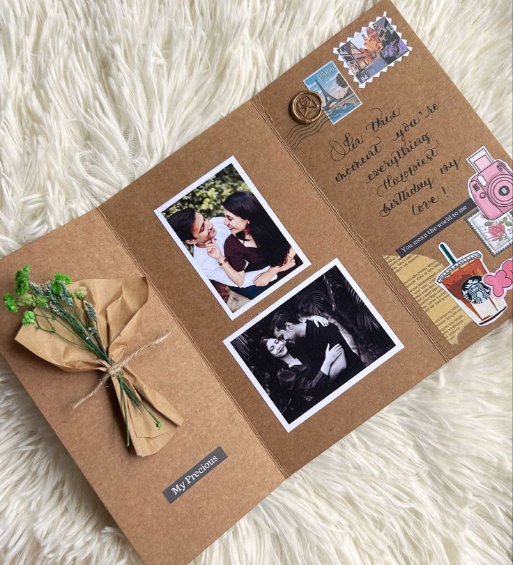 an open brown card with pictures and flowers on it, sitting on a white furnishing