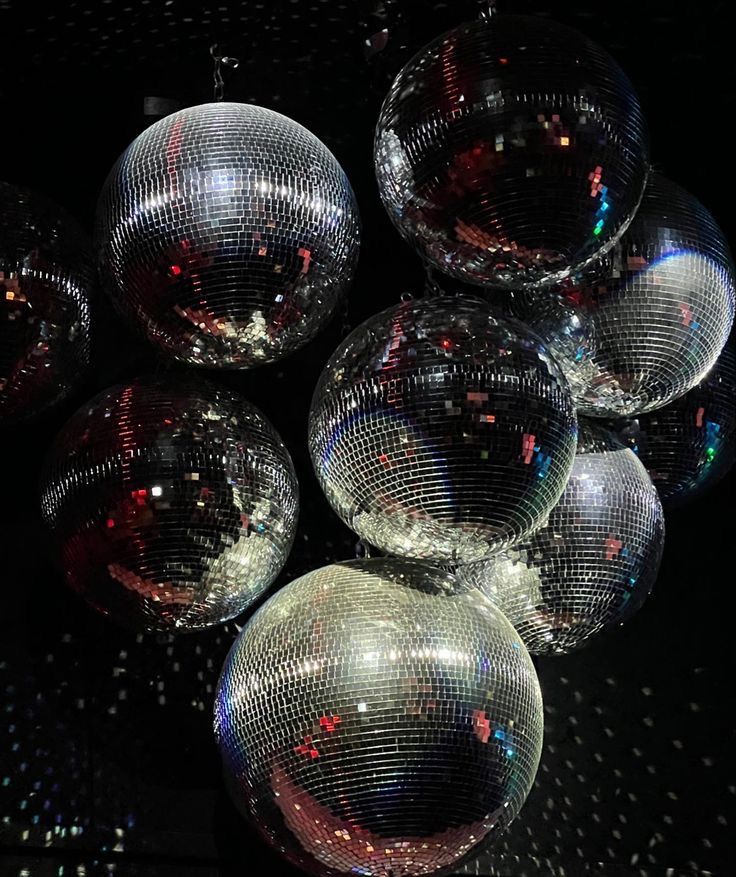 many shiny disco balls on a black surface