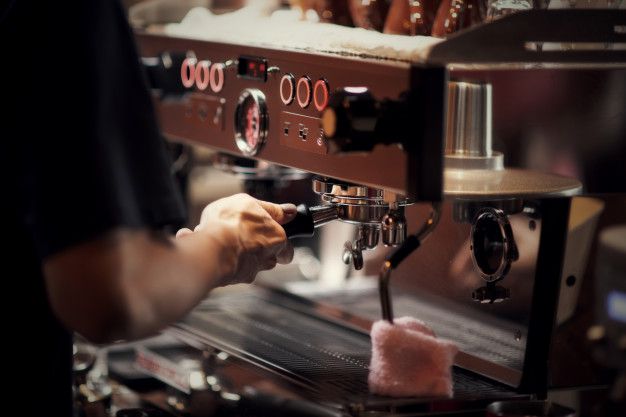 coffee cups being filled with espresso in front of an image of a baristak machine