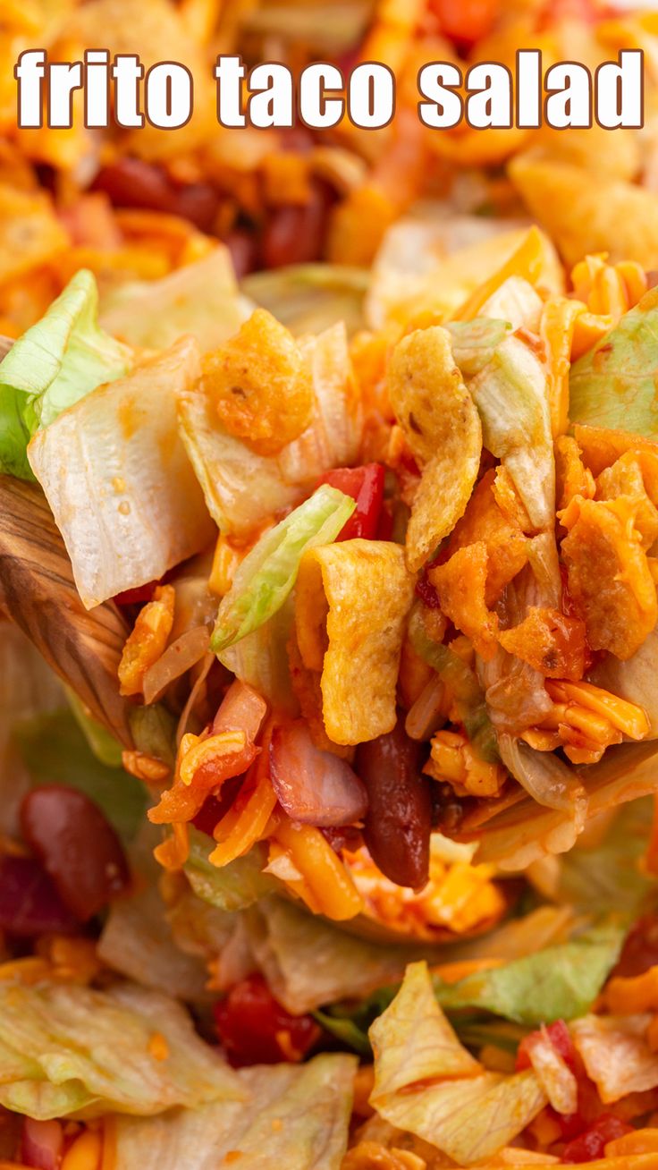 a close up of a salad on a spoon with the words frito taco salad above it