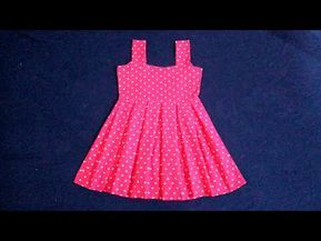 a pink and white polka dot dress sitting on top of a blue surface