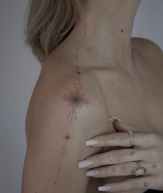 a woman's arm with tattoos on it and a ring in the middle of her left hand