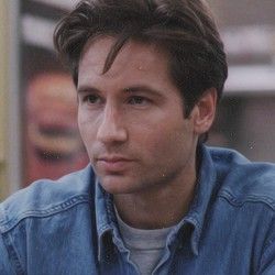 a man in a denim shirt looking at the camera