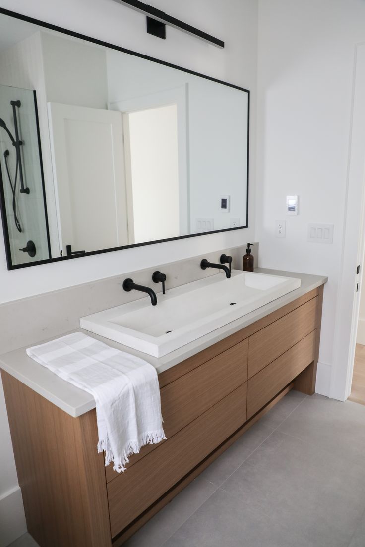 a bathroom with two sinks and a large mirror on the wall over it's counter