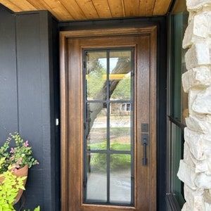 a wooden door sitting next to a planter filled with flowers