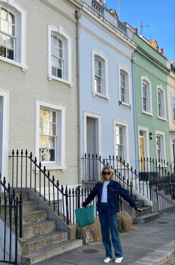 a woman standing in front of some colorful houses