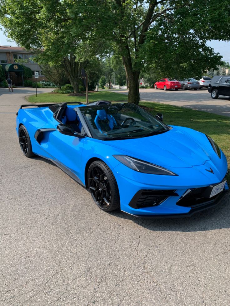 a blue sports car is parked on the street